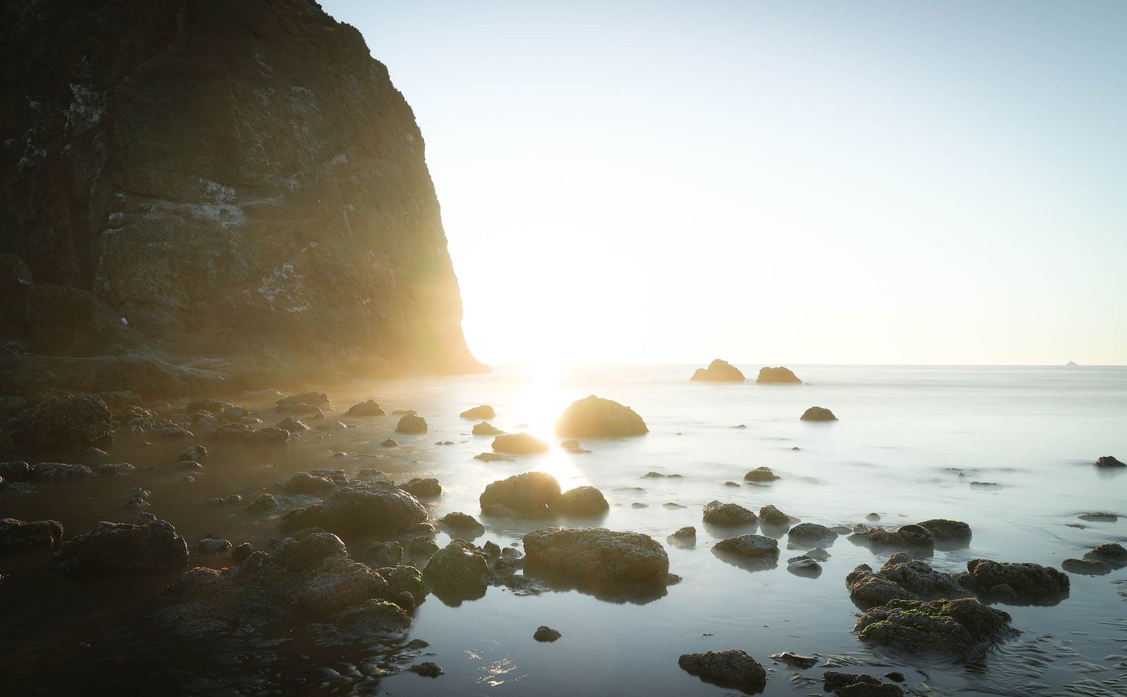Sun bursting over a rocky Oregon shore